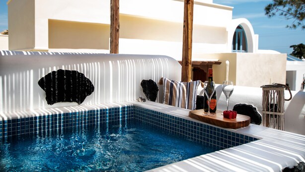 Una piscina con borde de azulejos y zona de terraza de madera.