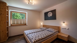 Una camera da letto con un letto in legno, una finestra con persiane, un'opera d'arte appesa al muro e un comodino.