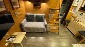 A compact room with a bed, a small table, a shelf, and a desk. - Estudio T34 - City Historic Center (Lisboa)