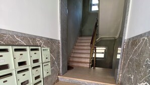 A staircase with marble walls and steps, leading to a landing with a window. - Estudio T34 - City Historic Center (Lisboa)