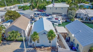 A coastal property with a marina, a detached house with a blue roof, and a small boat docked nearby.