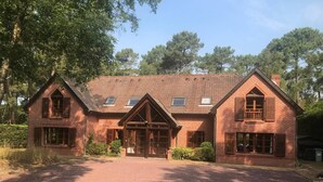 A brick building with a symmetrical facade, large windows, and a central entrance.