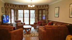 A living room with a large window, two sofas, a coffee table, and a television.