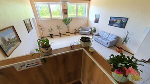 A reception area with a wooden counter, potted plants, a couch, and framed pictures on the walls. - Gabriel (Maardu)