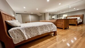Ein Schlafzimmer mit einem hölzernen Bett, einem Schminktisch, einem Spiegel und einer Decke mit Einbauleuchten.