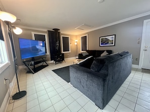 A living room with a TV, a fireplace, a sofa, and a rug.