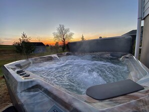 A hot tub with a view of a sunset and a house in the background. - Private Home, Hot Tub, Wifi, Rural Setting, Gas Stove, 70" SmartTV (Harpers Ferry)