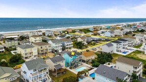 A coastal residential area with houses, a beach, and a yellow path. - 218 Brunswick in Holden Beach, perfect for family getaways! (Holden Beach)