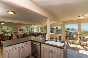 A spacious kitchen with a large island, a dining area with a view, and a cozy seating area with a sofa and chairs. - Moonstone Beach Retreat - Beach Lover's Getaway! (Trinidad)