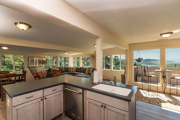 A spacious kitchen with a large island, a dining area with a view, and a cozy seating area with a sofa and chairs. - Moonstone Beach Retreat - Beach Lover's Getaway! (Trinidad)