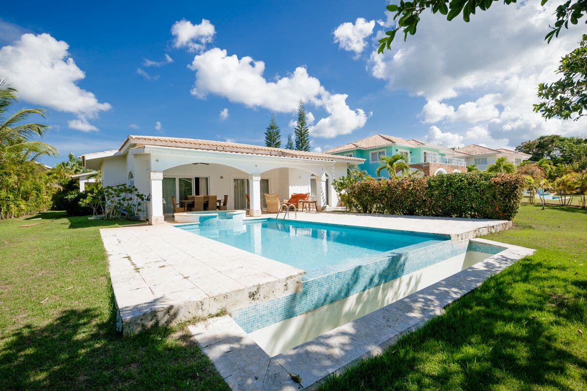 Ein modernes Haus mit Swimmingpool, einer Terrasse und Gartenmöbeln sowie einem gepflegten Garten.