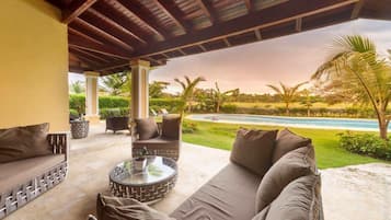 Relax in style with a view of the pool and lush surroundings from this outdoor seating area.
