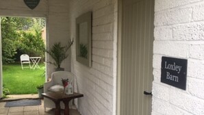 Eine Fassade aus weißen Ziegeln mit einer Tür, auf der 'Loxley Barn' steht.