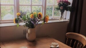 Ein Holztisch mit zwei Untertassen und einer Blumenvase.