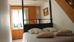 A bedroom with a bed, wooden headboard, and a window with curtains. - Detached house in an 18th-century property. (Mesnil-en-Ouche)