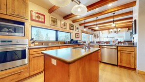 A modern kitchen with wooden cabinets, stainless steel appliances, and a large island. - Val DIsere 10 5-Star Luxury with Game room and Gorgeous Mountain Views, Walk to The Village. by RedAwning (Mammoth Lakes)