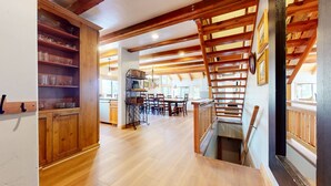 A spacious kitchen with wooden cabinets, a dining area with a large table and chairs, and a staircase with wooden railings. - Val DIsere 10 5-Star Luxury with Game room and Gorgeous Mountain Views, Walk to The Village. by RedAwning (Mammoth Lakes)
