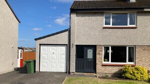A two-story residential house with a garage, a front door, and a small front yard. - 3bed House - Family Friendly - Close To Lochness (Inverness)