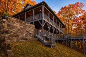 A two-story building with a balcony and a staircase leading to the upper level. - The Great Dane: Family and Pet Friendly Mtn Top Cabin, Double Porch, High-Speed (Ferguson)