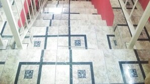 A staircase with a red wall and patterned floor tiles. - Immaculate 2-bed Apartment in Spanish Town (Spanish Town)