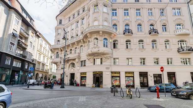 A historic building with ornate architecture, multiple balconies, and a prominent restaurant named "AKCIOS." - Luxurious sunlit suite in a prime location with a private city-view balcony, A/C (Budapest)