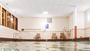Ein Schwimmbecken mit klarem Wasser, einer gefliesten Wand und einer Decke mit Leuchtstofflampen.