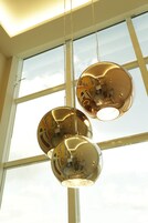 Tres lámparas colgantes esféricas en una habitación con ventanales amplios.