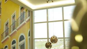 A multi-level interior with a staircase, large windows, and a mural on the wall.