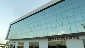 A modern building with a glass facade and a sign that reads "RESTAURANTE" at the bottom.