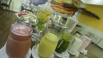 Een buffet met verschillende fruitsmoothies en vruchtensappen.