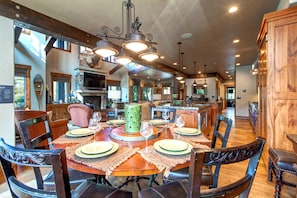 A spacious dining area with a wooden table set for six, surrounded by dark wooden chairs.