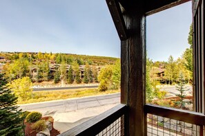 Blick aus einem Fenster auf ein Wohngebiet mit Häusern, einer Straße und einer hügeligen Landschaft.
