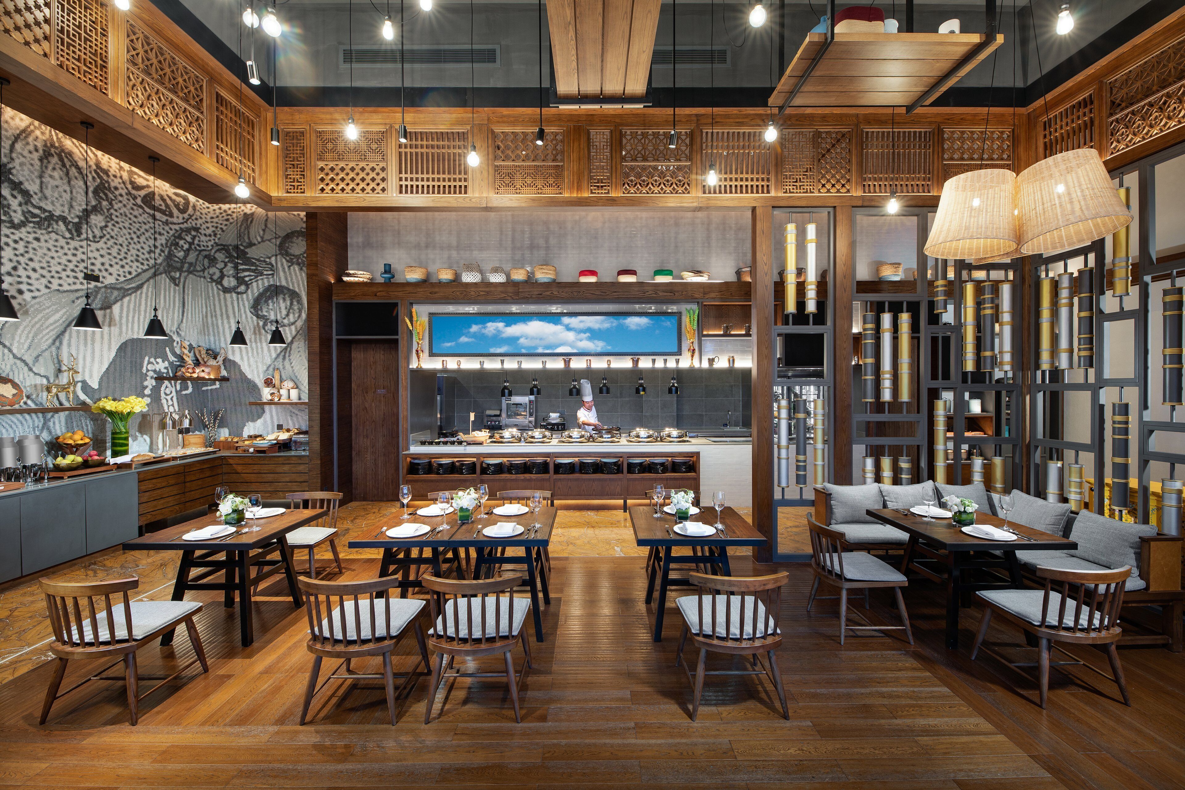 Un restaurante con mobiliario de madera, una gran pantalla de televisión y una variedad de platos expuestos en estanterías.