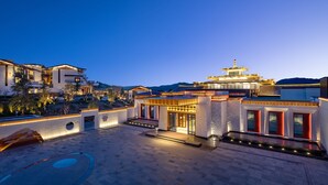 A modern hotel with a spacious courtyard, traditional architectural elements, and a well-lit entrance.