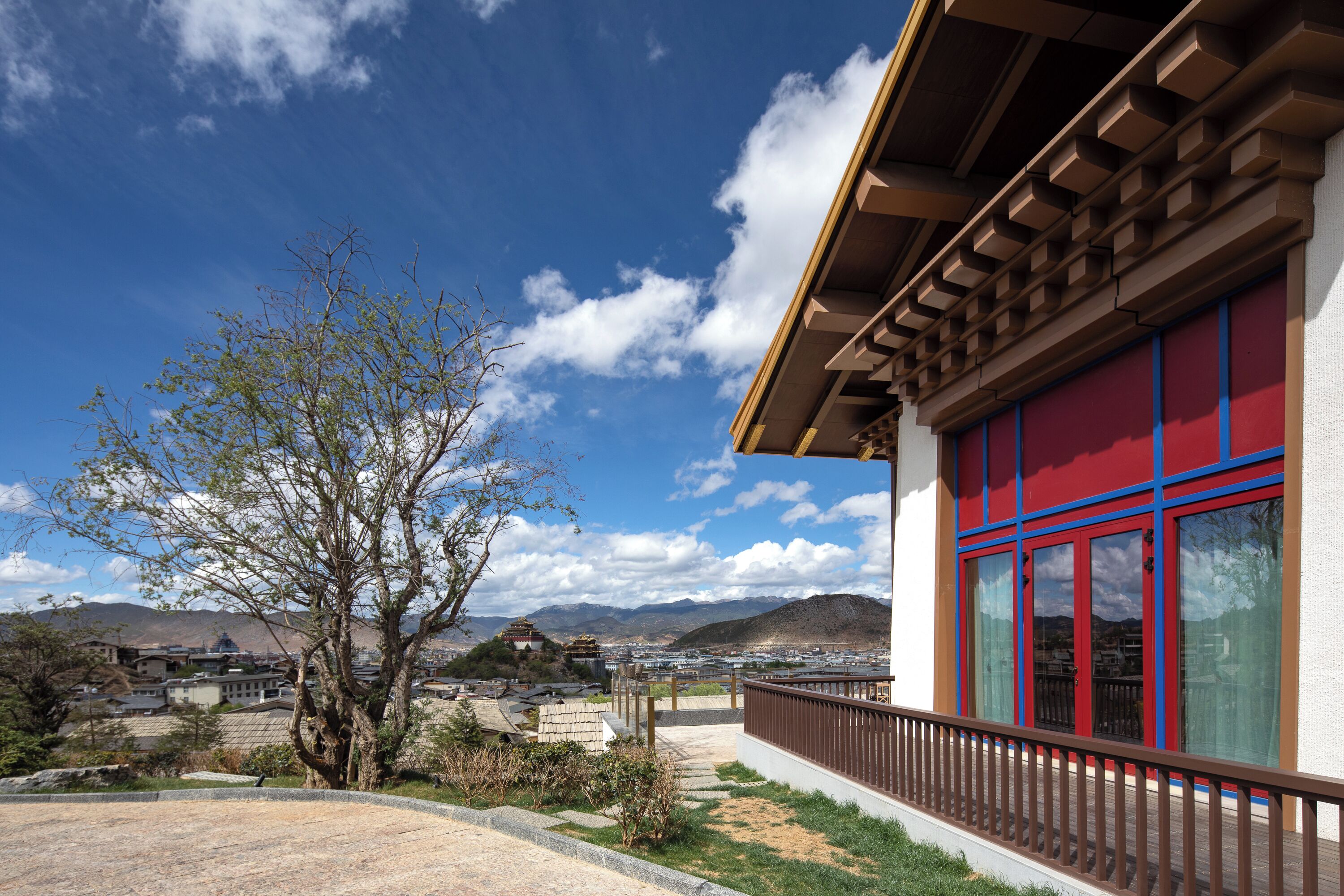 A building with large windows and a balcony overlooking a mountainous landscape.