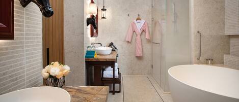 A modern bathroom with a large bathtub, a double sink vanity, and a glass-enclosed shower.