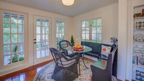 A dining area with wicker chairs, a glass table, and a decorative bowl of fruit. - New Braunfels Bungalow~Near Downtown (New Braunfels)