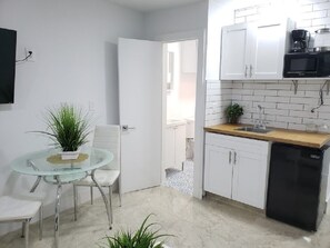 A compact kitchen with white cabinets, a black dishwasher, and a wooden countertop. - Lil' n' Cozy Studio ❤ Near FLL Beach, Las Olas Shops & Nightlife (Fort Lauderdale)