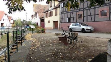 En gata med en parkerad bil, en cykel och en skylt.