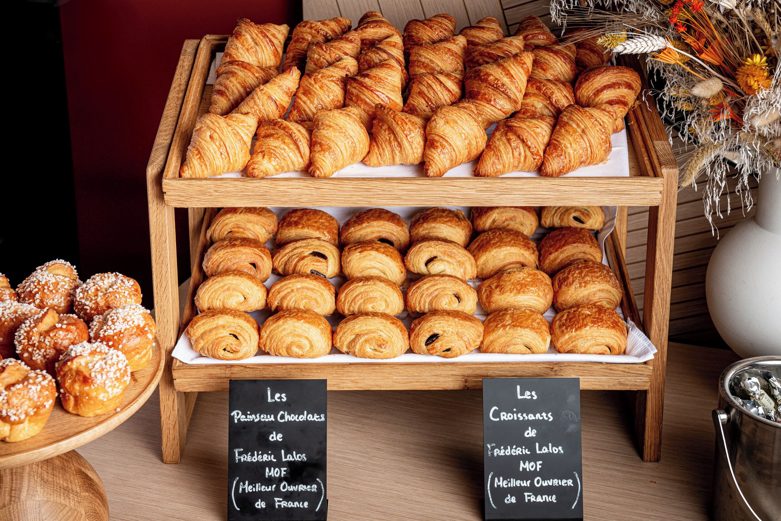 A display of various pastries on wooden stands with labels indicating different types.