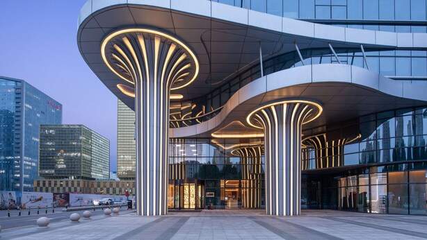 A modern building with a curved facade and illuminated structural elements. - Hilton Garden Inn Zibo Zhangdian (Zibo)