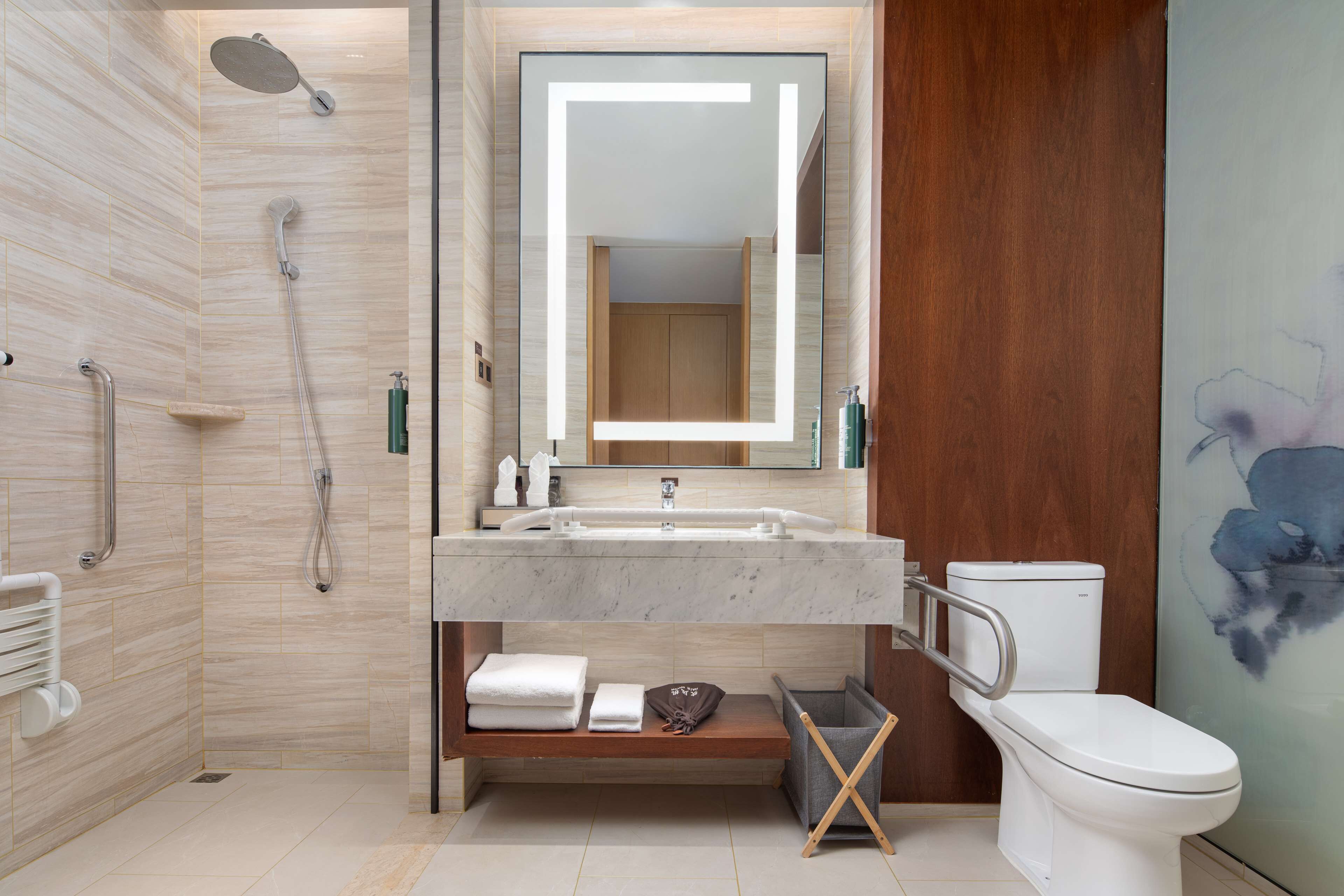Une salle de bain moderne équipée d’une douche, de toilettes et d’un meuble-lavabo.