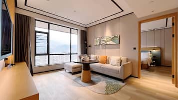 Suite Deluxe, 1 cama King size | Área de sala de estar | Televisión LCD de 50 pulgadas con canales por cable y televisión