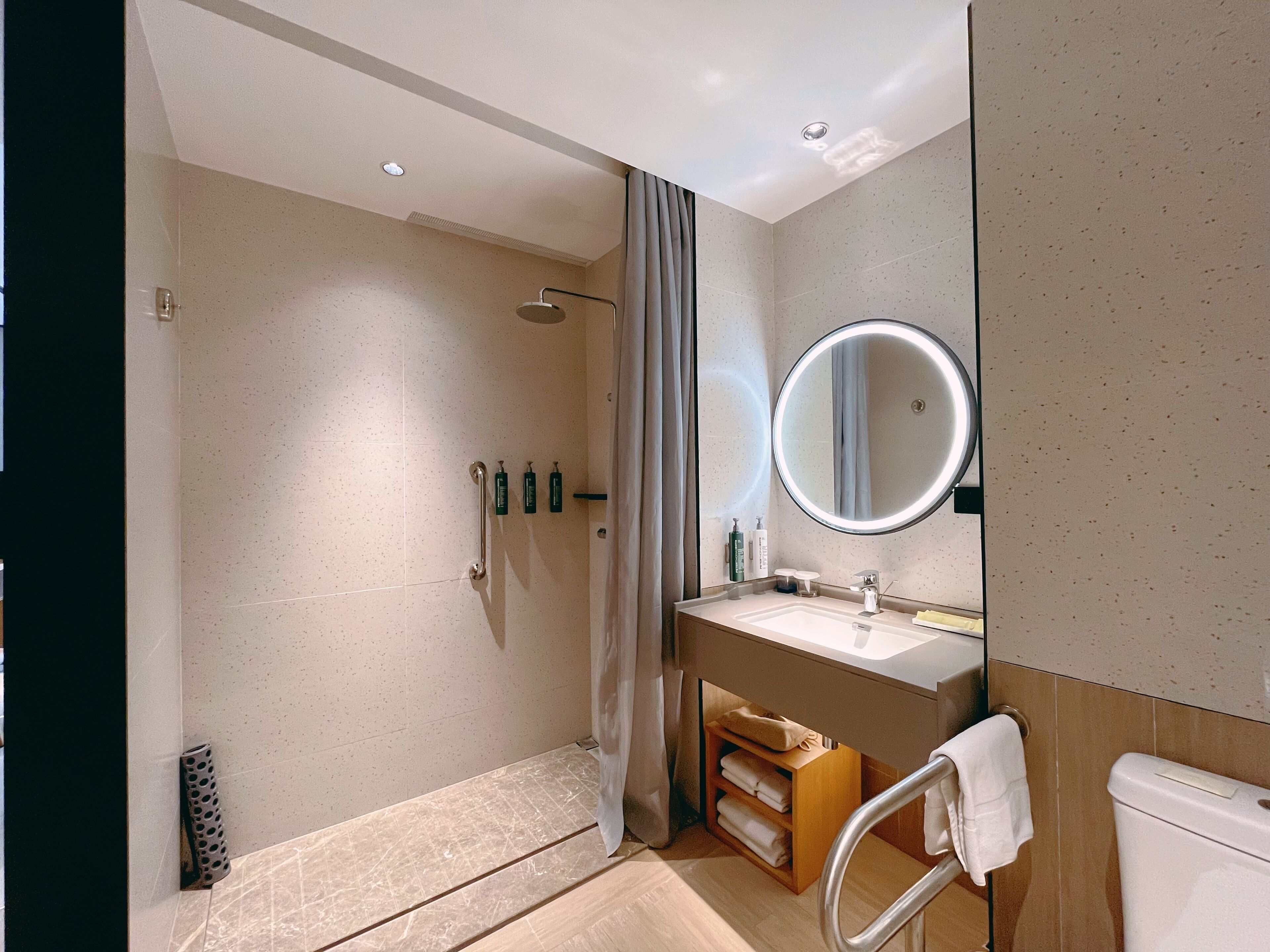 Un baño moderno con ducha, inodoro y lavamanos.