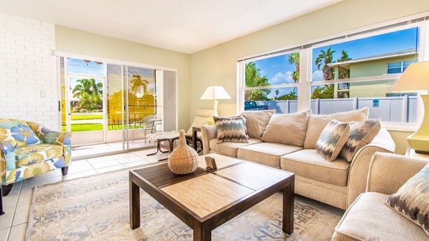 A living room with a sofa, coffee table, and a patterned rug. - Maximo Marina Condo • Heated pool, Near Pass-a-Grille, Downtown & Eckerd (St. Petersburg)
