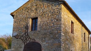 A stone building with a pitched roof and a small window.