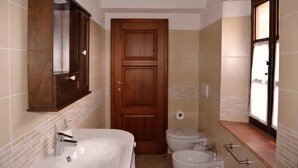 A bathroom with a wooden door, a white sink, and a toilet.