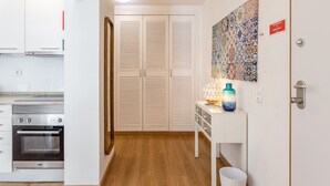 A modern kitchen with built-in appliances, a white wardrobe, and a decorative wall piece. - FLH Best of Principe Real Liberdade in the Heart o (Lisboa ciudad)