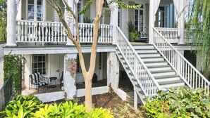 A two-story house with a balcony, a staircase, and outdoor seating. - Grand 10BR Charleston Home with Speakeasy Bar, Gym (Charleston)
