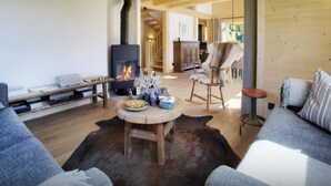 Un salon chaleureux avec une cheminée, des meubles en bois et un tapis.